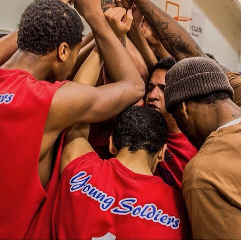 Young Soldiers players huddled together in red team jerseys before a game